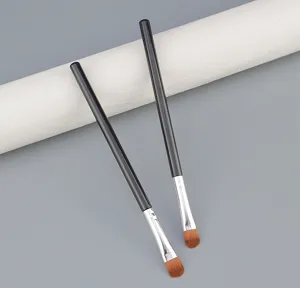 Detalle de pincel de maquillaje individual, mango negro y cerdas marrones para ojos más precisos.