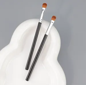 Vista detallada de dos pinceles de maquillaje de mango negro para aplicación precisa de delineador.