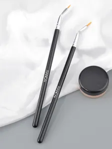 Detailed close-up of angled eyeliner brushes and potted cream, ideal for precise makeup.