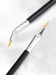 Close-up detail view of angled eyeliner makeup brushes with fine tips on textured white background.