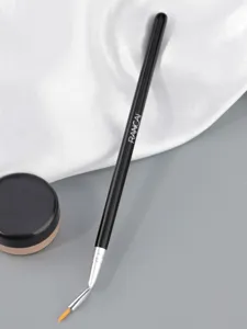 Close-up detail of angled eyeliner and concealer makeup brush with fine tip and ergonomic handle.