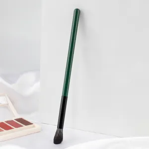 Detailed shot of a green handle flame highlighter makeup brush with soft bristles for precise glow.
