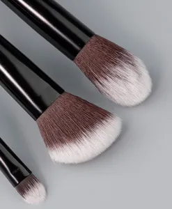 Makeup brush detail showing soft bristles and sleek black handle for precise application.