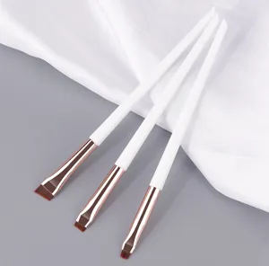 Λεπτομερής λήψη πινέλων φρυδιών και eyeliner με λευκές λαβές για ακριβή εφαρμογή μακιγιάζ.
