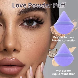 Detail view of purple triangular velvet makeup powder puff for wet and dry foundation.