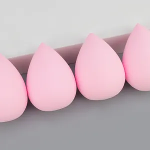 Close-up detail of soft pink makeup sponge blender, teardrop shape for flawless base application.