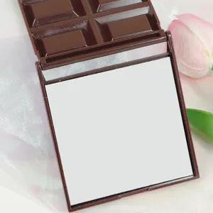 Primo piano dello specchio per trucco pieghevole a forma di cioccolato carino con guscio marrone.