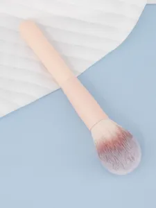 Brocha de maquillaje suave con mango rosa y cerdas degradadas para aplicación de polvos.