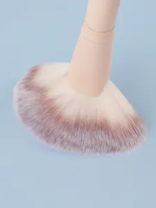 Close-up detail shot showing the soft gradient bristles of the large fan makeup brush.