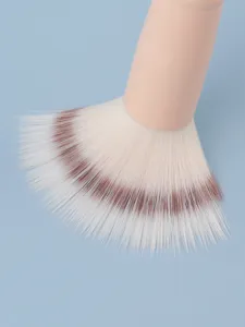 Gedetailleerde close-up van zachte synthetische make-upborstel met roze handvat en haren.