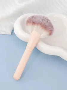 Large fan makeup brush with flesh-colored handle and soft bristles for face powder detail.