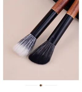 Detailed view of portable cosmetic makeup brush with wooden handle and soft bristles.