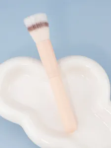 Roze handvat detail make-up borstel met zachte haren op witte keramische tray close-up