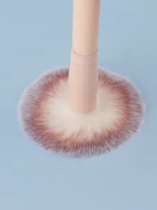 Primer plano detallado de brocha de maquillaje suave con cerdas densas y mango liso.