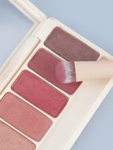 Detailed closeup shot of multi-color eyeshadow palette with cosmetic brush and natural tones.