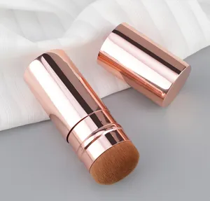 Portable retractable makeup brush with rose gold metallic case and soft brown bristles detail