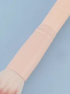 Primer plano detallado de una brocha de maquillaje profesional con cerdas suaves y mango.