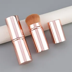 Large portable retractable makeup brush with rose gold aluminum case and soft bristles.