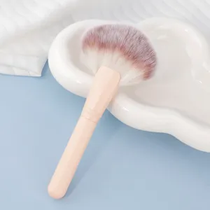 Large fan makeup brush with pastel handle, soft bristles for highlighting and setting powder.