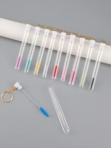 Detailansicht von Wimpernbürsten im klaren Etui mit Glitzergriffen und goldenen Schlüsselringen.