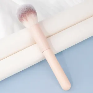 Brocha de maquillaje suave y esponjosa con mango rosa para aplicación profesional de polvos