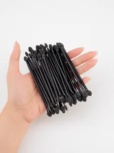 Close-up detail of black double-ended sponge eyeshadow brushes, portable makeup tools set.