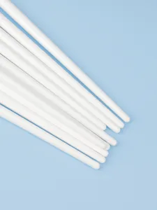 Detail view of white cosmetic brush handles, smooth surface and clean product presentation.