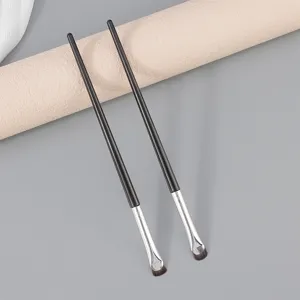 Gedetailleerde opname van fijne eyelinerpenselen, zwarte handvatten met zilveren ferrule.