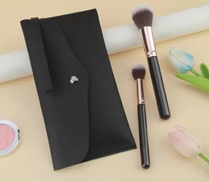 Detailed view of black PU leather makeup brush storage bag and soft cosmetic brushes set.