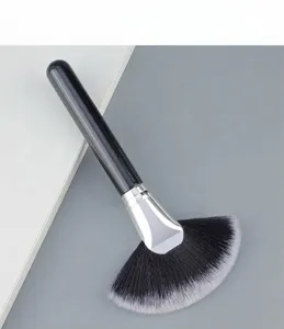 Detail shot of large black handle fan makeup brush with soft fibers for highlighters and dust removal.