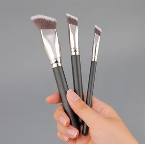 Close-up of angled makeup brushes with soft bristles and matte black handles for flawless base.
