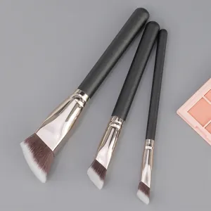 Detail shot of three angled makeup brushes with black handles and soft dual tone bristles.