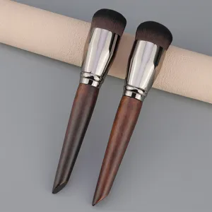 Detailed view of round foundation makeup brush with wooden handle and dense bristles.