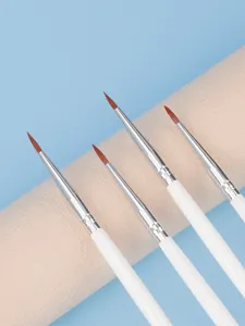 Detail shot of fine makeup brushes with white handles and brown tips for precise application.