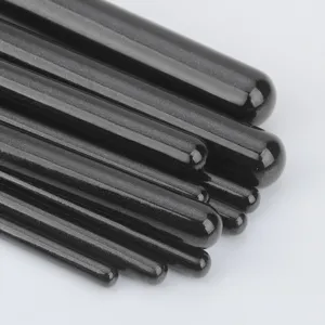 Black glossy makeup brush handles set close-up, premium smooth finish, professional beauty tool.