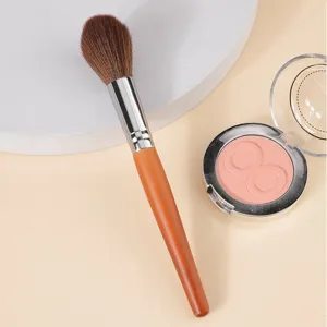 Detailed view of flame makeup brush with wooden handle and soft synthetic bristles for blush.
