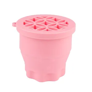 Pink collapsible silicone washing cup for makeup brushes, portable cleaning and storage bowl.