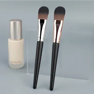 Professional tongue-shaped foundation brush with wooden handle and soft synthetic bristles.