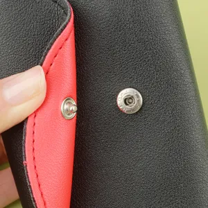 Nahaufnahme Detail des schwarzen und roten Leder Manikuere Etuis mit Druckknopf.