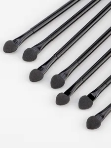 Detail view of double-ended sponge eyeshadow brushes with sleek black handles and soft tips.