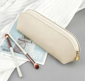 Estuche minimalista de piel sintética beige con cremallera y juego de brochas de maquillaje.