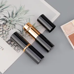 Portable retractable makeup brush in black and gold design, ideal for loose powder application.