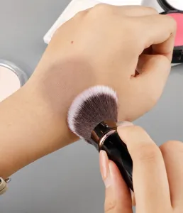 Portable retractable makeup brush with soft bristles for flawless powder blush application.
