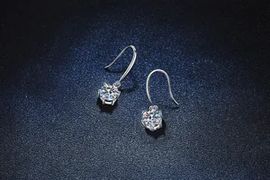 Primer plano de elegantes pendientes colgantes de moissanita con seis garras brillantes.