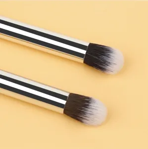 Close-up detail of makeup blending brushes with black-white striped handle and soft bristles.