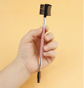 Dual-ended eyelash brush and eyebrow comb with pink handle for professional makeup application.