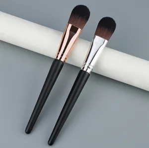 Detail shot of flat foundation makeup brush with soft bristles, black handle and metallic ferrule.