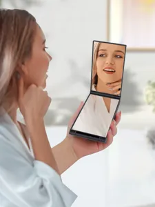 Vista dettagliata dello specchio pieghevole portatile tenuto da modella in stanza.