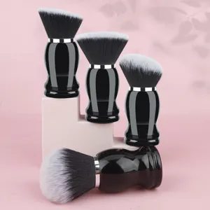 Detailed shot of professional black handle makeup brush set for powder and nail dust application.