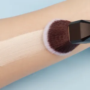 Detailansicht großer Make-up-Pinsel mit geometrischem Griff und dichten Borsten für Puder.